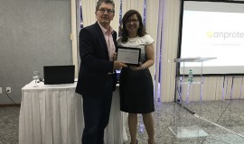 Sheila Pires, superintendente executiva da Anprotec, entrega placa de reconhecimento a Sergio Risola, Diretor de Empresas durante a gestão 2016-17.